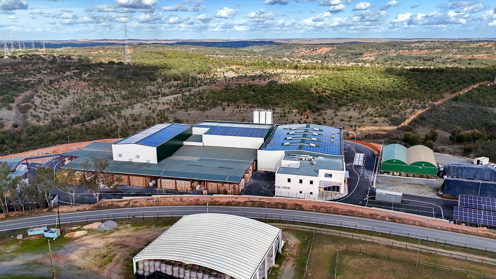 Aerial view of the solar-roofed hemp-lime block factory among Alentejo hills